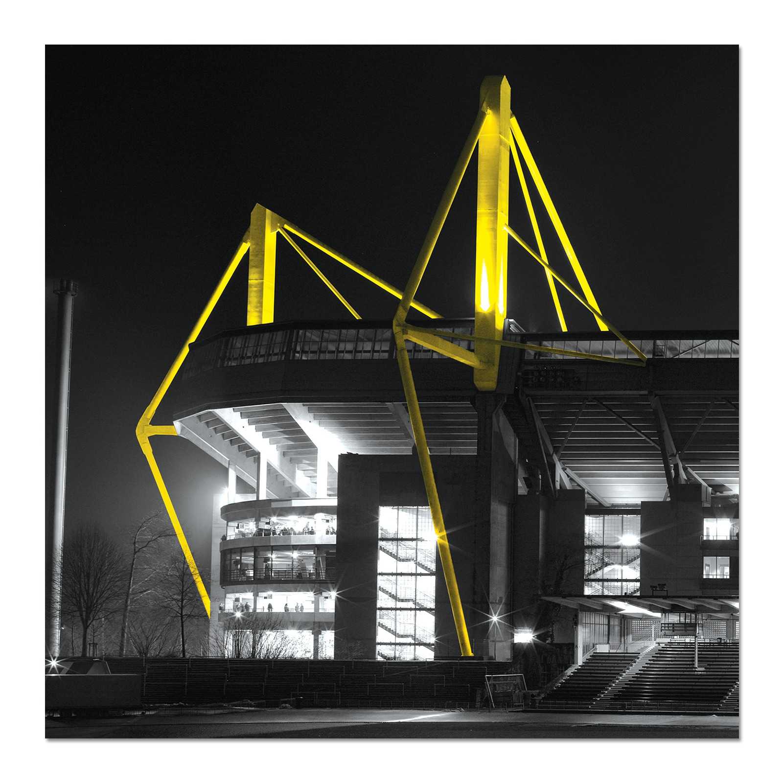 Kunstdruck „SIGNAL IDUNA PARK - I“ 50x50 cm zeigt die Westtribüne des SIGNAL IDUNA PARK bei Nacht, mit leuchtend gelben Stahlpylonen auf schwarzweißem Hintergrund.