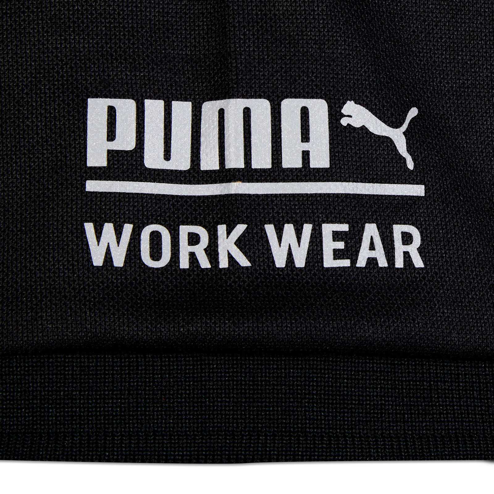 Detailansicht des schwarzen BVB-Polo Arbeitsshirts mit weißem PUMA-Logo und dem Schriftzug "WORK WEAR" auf der Vorderseite.