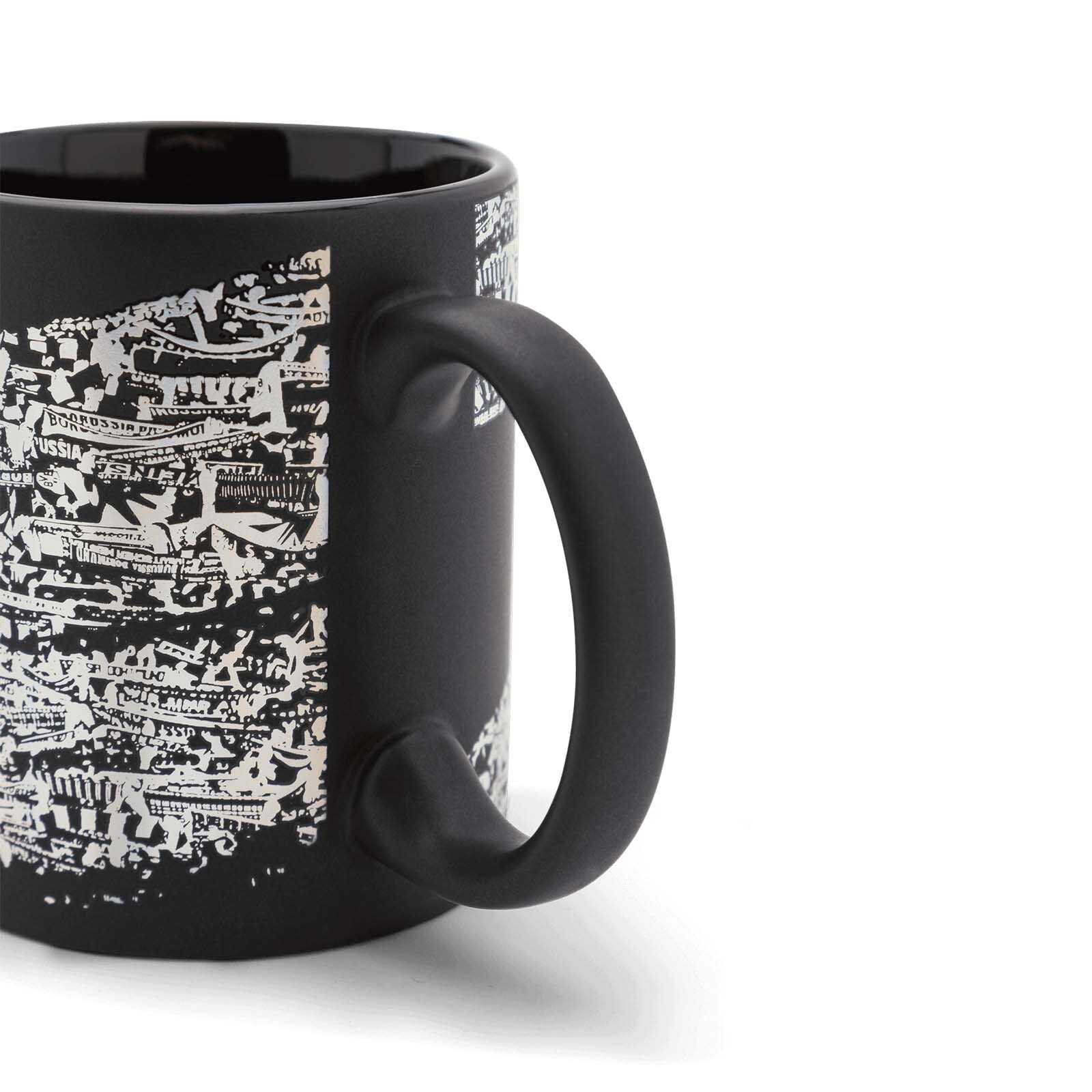 Seitenansicht der schwarzen BVB-Tasse Südtribüne mit weißem Fan-Motiv der Südtribüne; Henkel und Innenfläche sind schwarz.