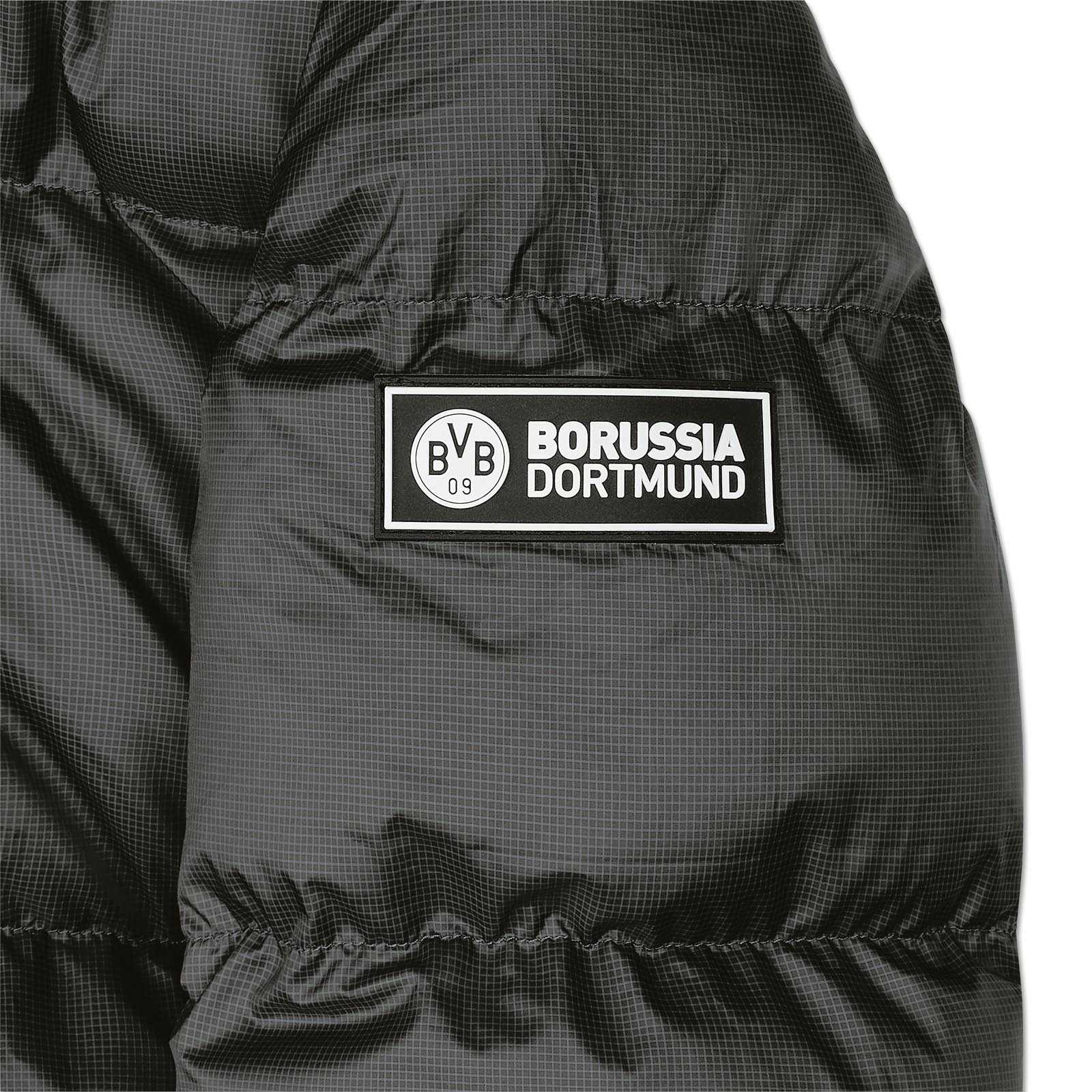 Detailansicht der schwarzen BVB Padded Jacket Damen mit gestepptem Stoff und aufgenähtem Patch mit BVB-Emblem und Schriftzug "Borussia Dortmund".