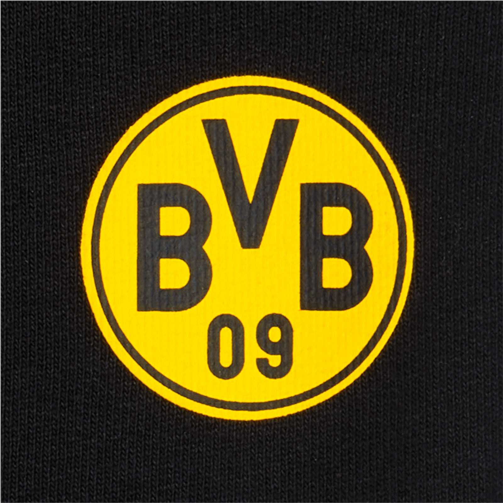 Detailansicht der BVB CLUB Freizeithose Kinder in schwarzgelb mit prominentem BVB-Emblem auf dem Stoff.
