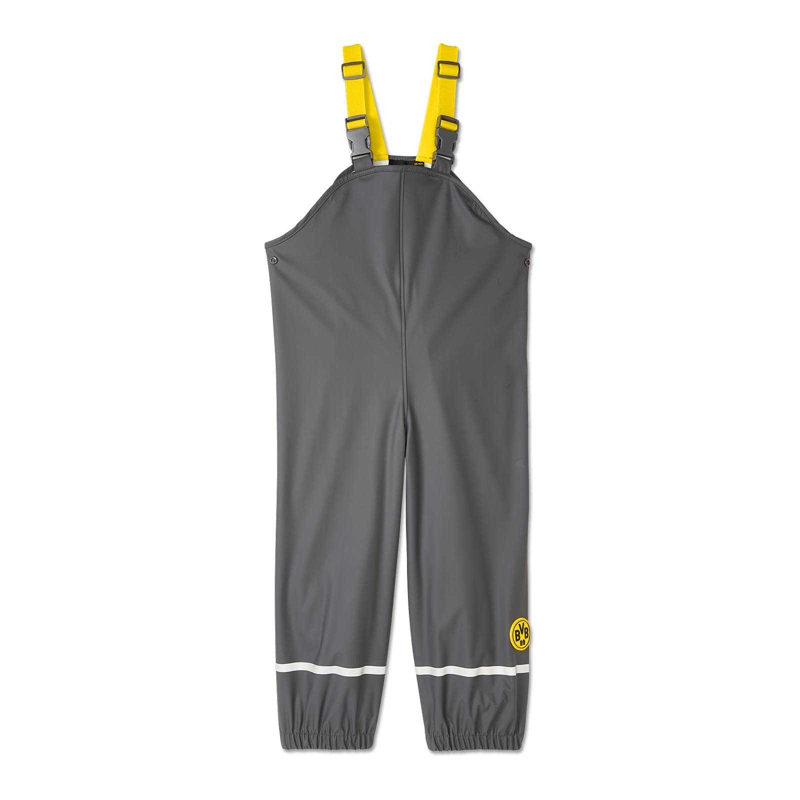Vorderansicht der BVB Regenhose für Kleinkinder in Grau mit gelben Trägern, reflektierender Linie und BVB-Emblem am Bein.