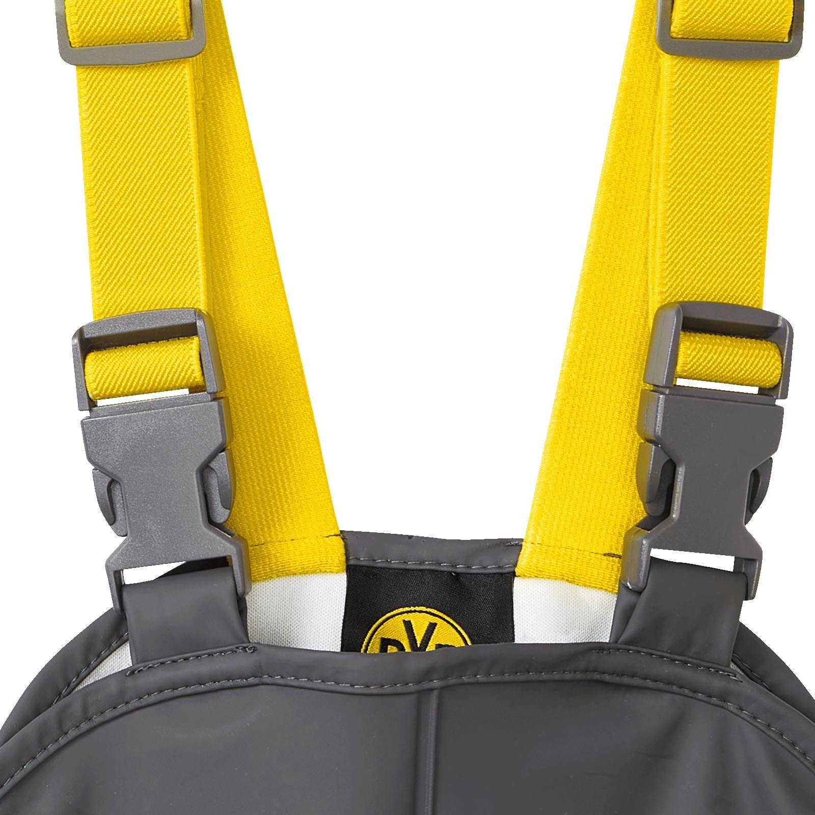 Detailansicht der BVB Regenhose für Kleinkinder in grau mit gelben Trägern und sichtbarem BVB-Emblem an der Vorderseite.