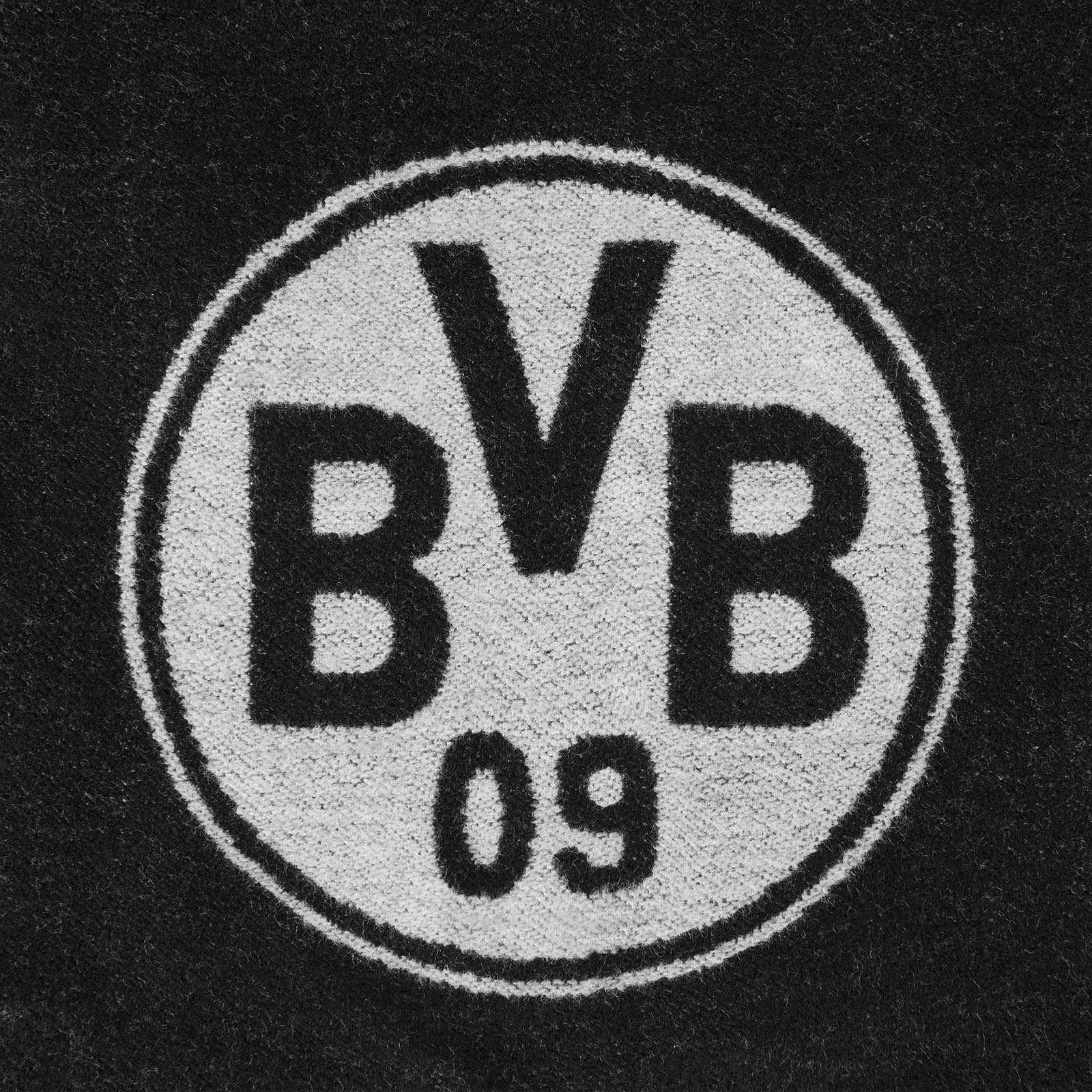 Detailansicht des BVB-Emblems auf dem BVB Schal exklusiv mit Fransen. Das schwarzgelbe Vereinslogo ist mittig auf dem Stoff abgebildet.