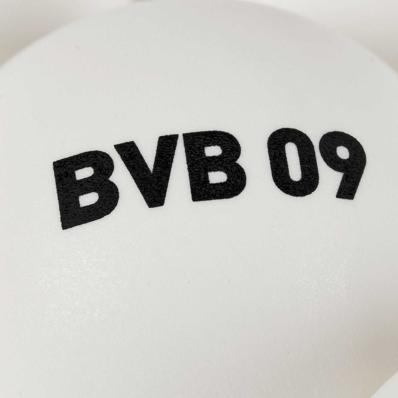Detailansicht eines weißen Balls aus dem BVB Tischtennisbälle 6er Set mit schwarzem Aufdruck "BVB 09".