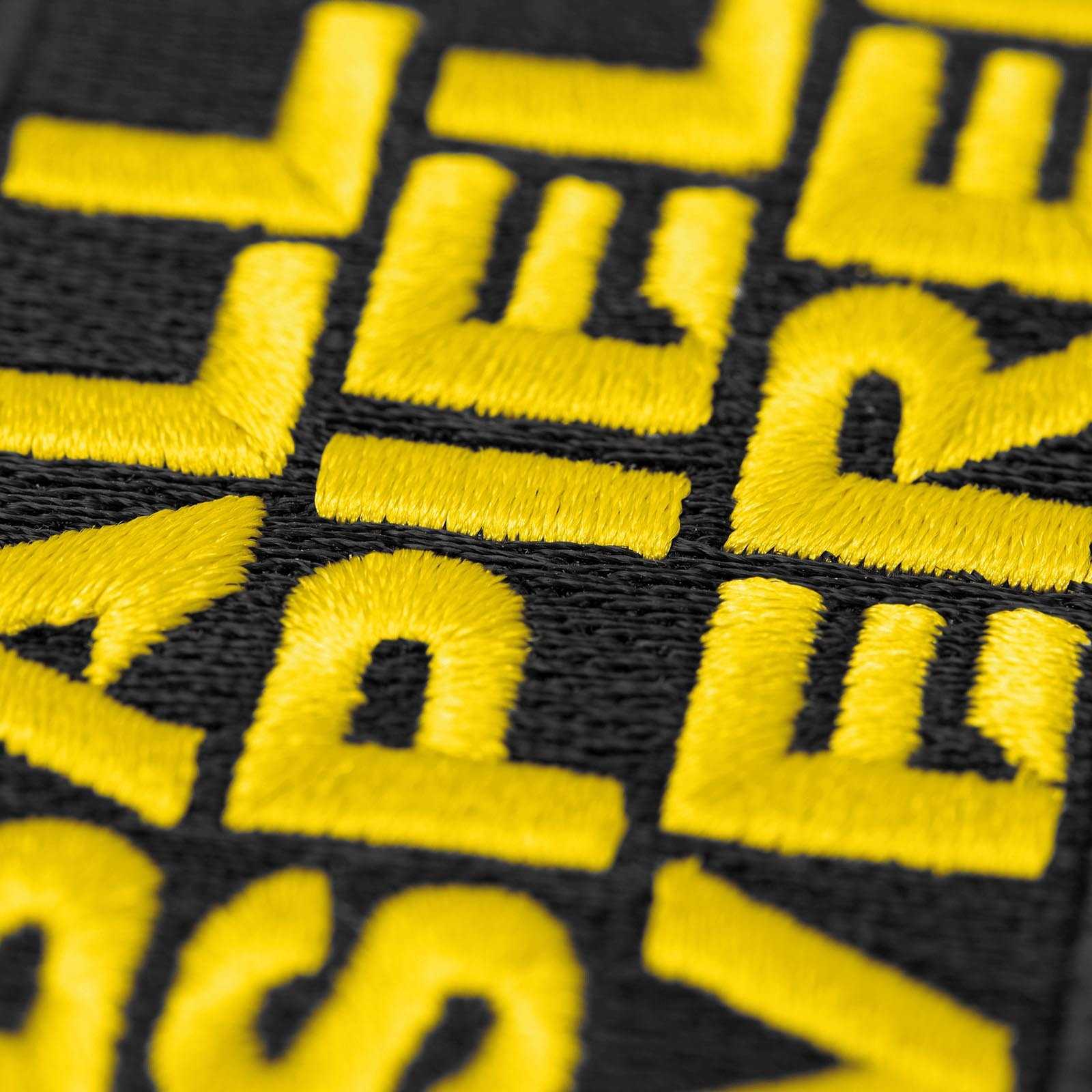 Detailansicht des BVB Aufnähers Ballspielverein mit gelber Stickschrift auf schwarzem Hintergrund in typisch schwarzgelben Farben.