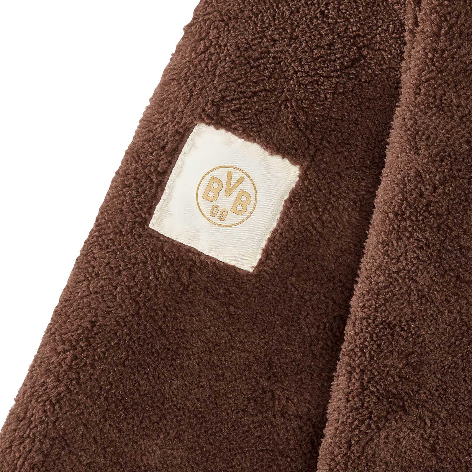 Detailansicht der braunen BVB Teddy Fleecejacke Frauen mit weichem Fleece und aufgenähtem weißen Patch mit BVB-Emblem.