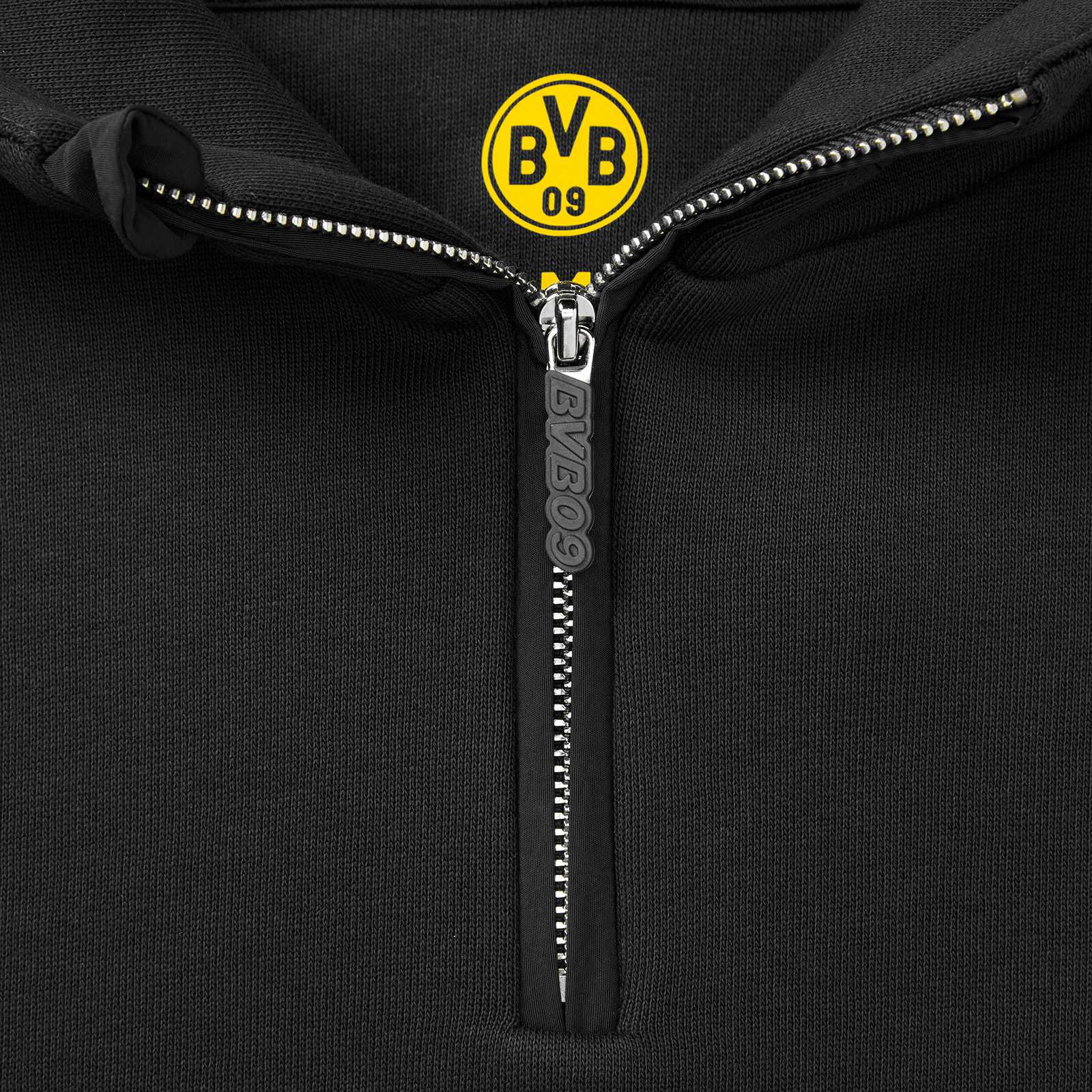 Detailansicht des schwarzgelben BVB Underground Hoodies mit sichtbarem BVB-Emblem am Kragen und Reißverschluss mit „BVB09“-Prägung.