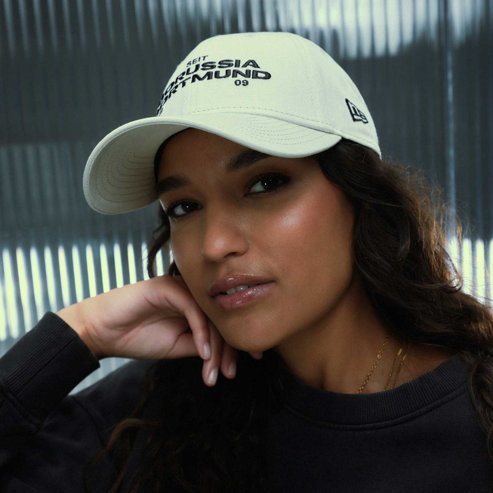 Ein weibliches Model trägt die New Era Kappe