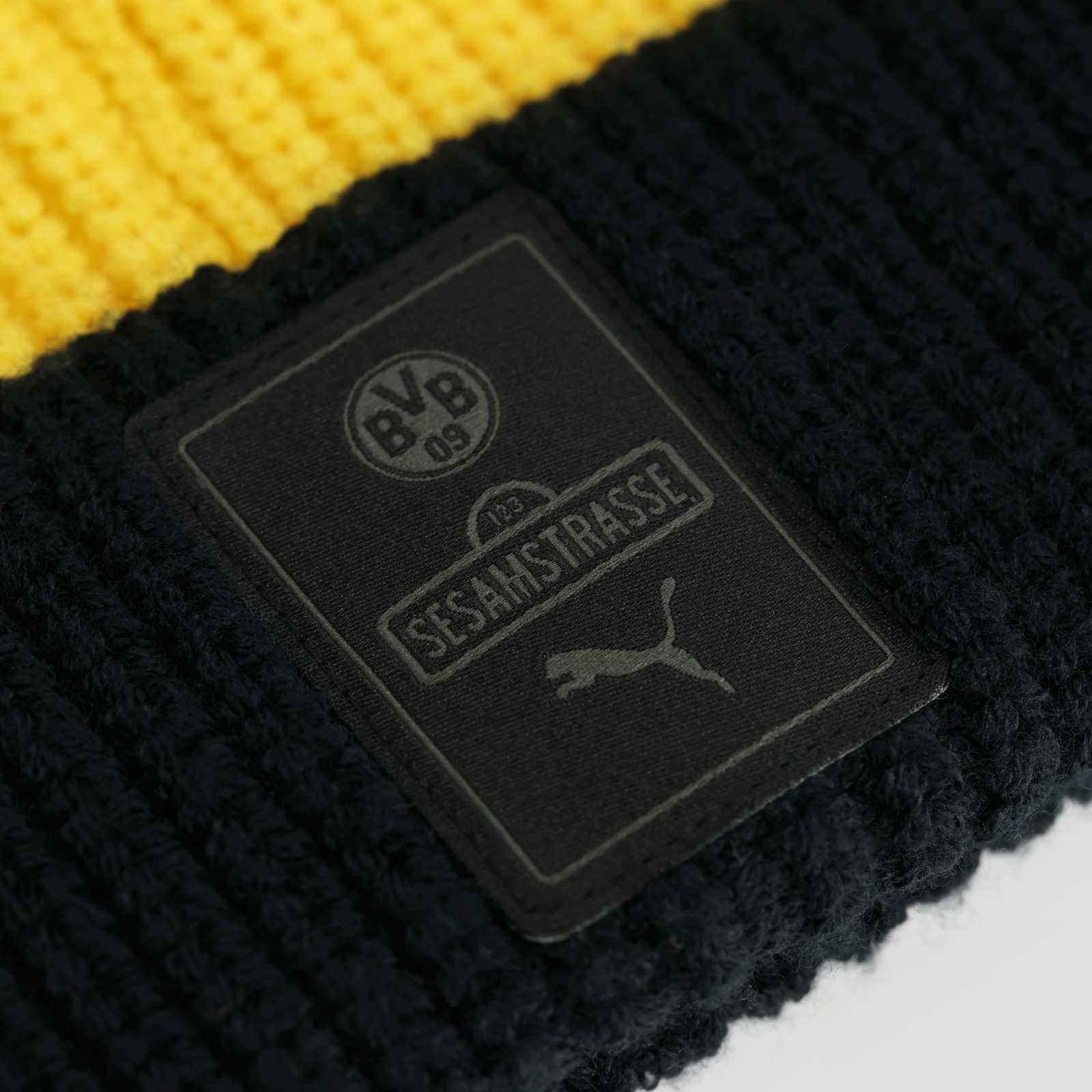 Detailansicht des schwarzen Sesamstraßen- und PUMA-Labels auf dem umgeklappten Mützenrand