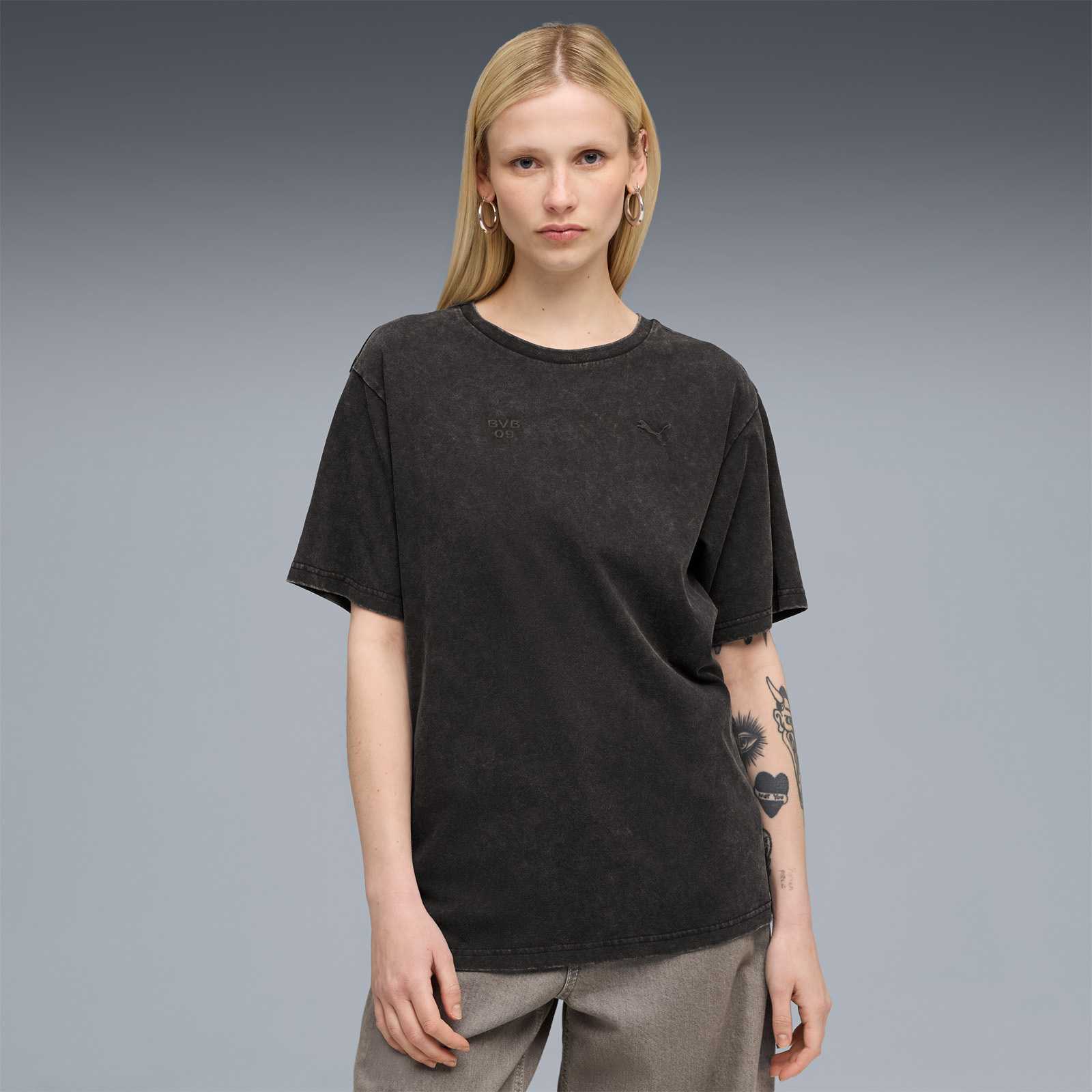Ein weibliches Model mit blonden Haaren trägt das PUMA-Shirt